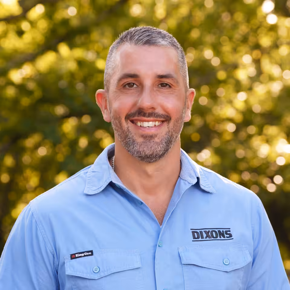 Smiling man in blue Dixons shirt outdoors