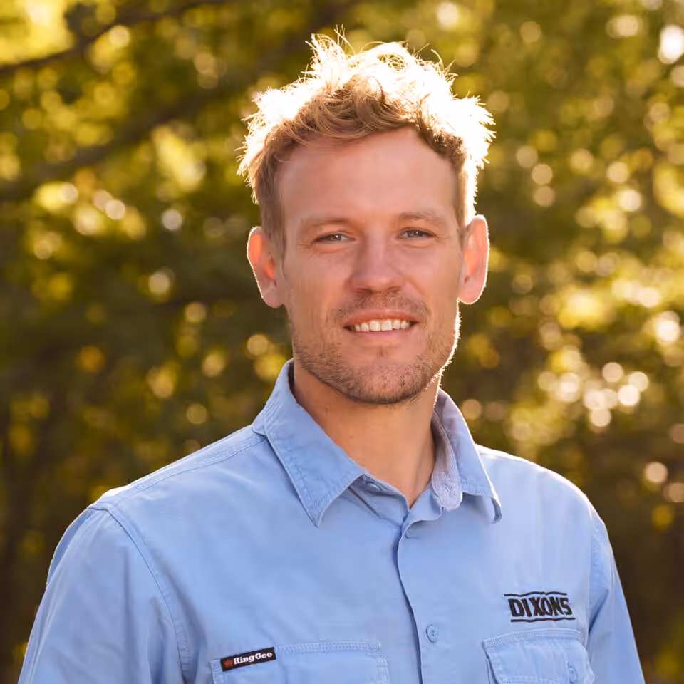 Smiling man in blue shirt outdoors