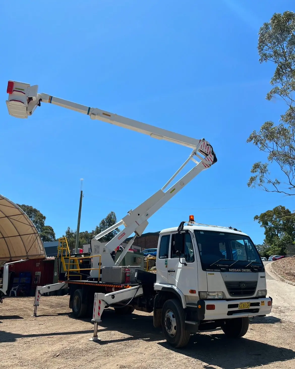 New elevated work platform available for hire, featuring an extended arm and basket, ideal for reaching high places like powerlines over trees.