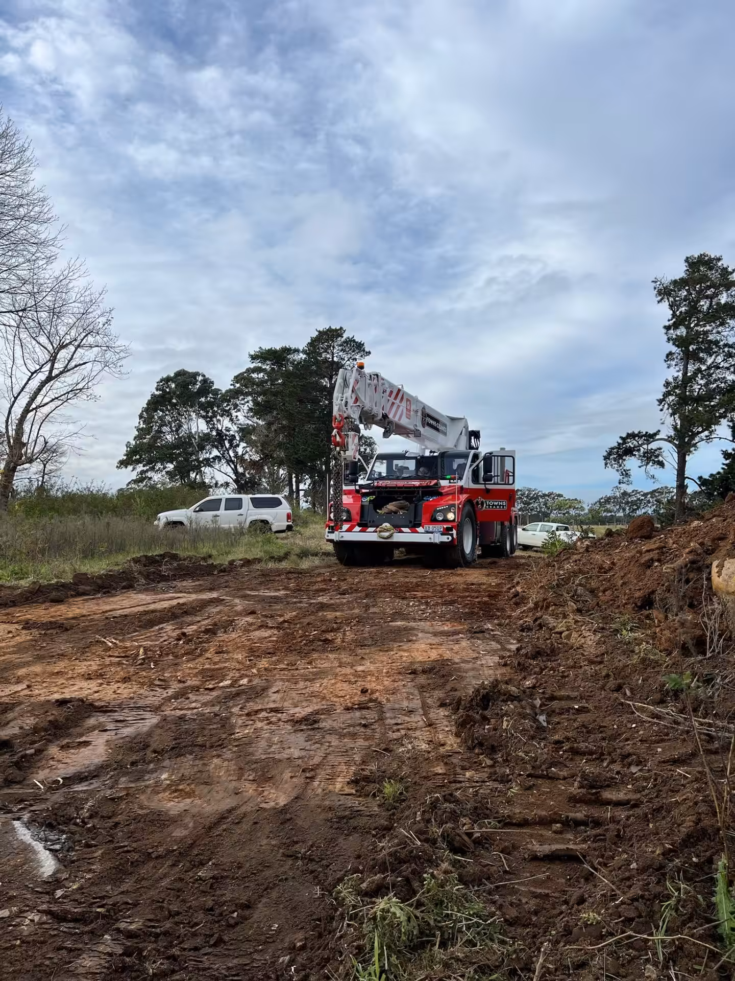 Red crane truck on muddy construction site