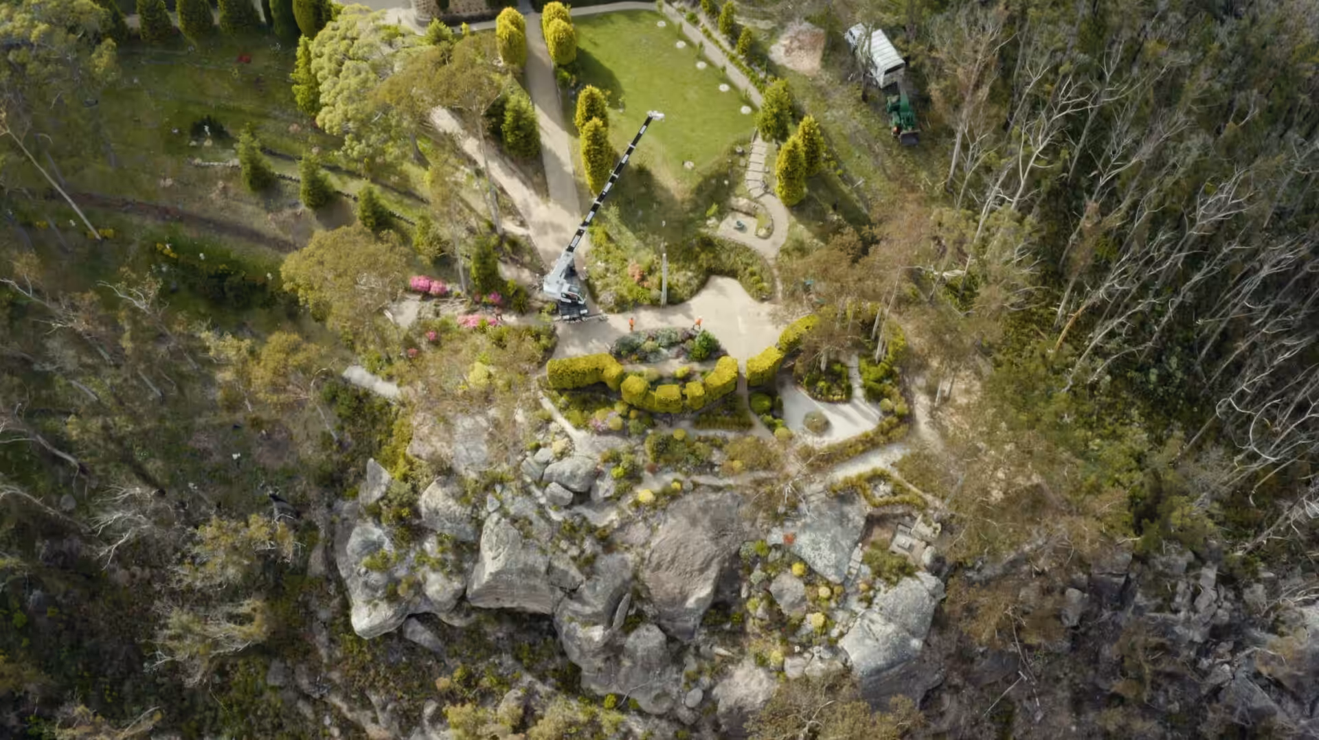 Aerial view of landscaped cliffside garden with crane