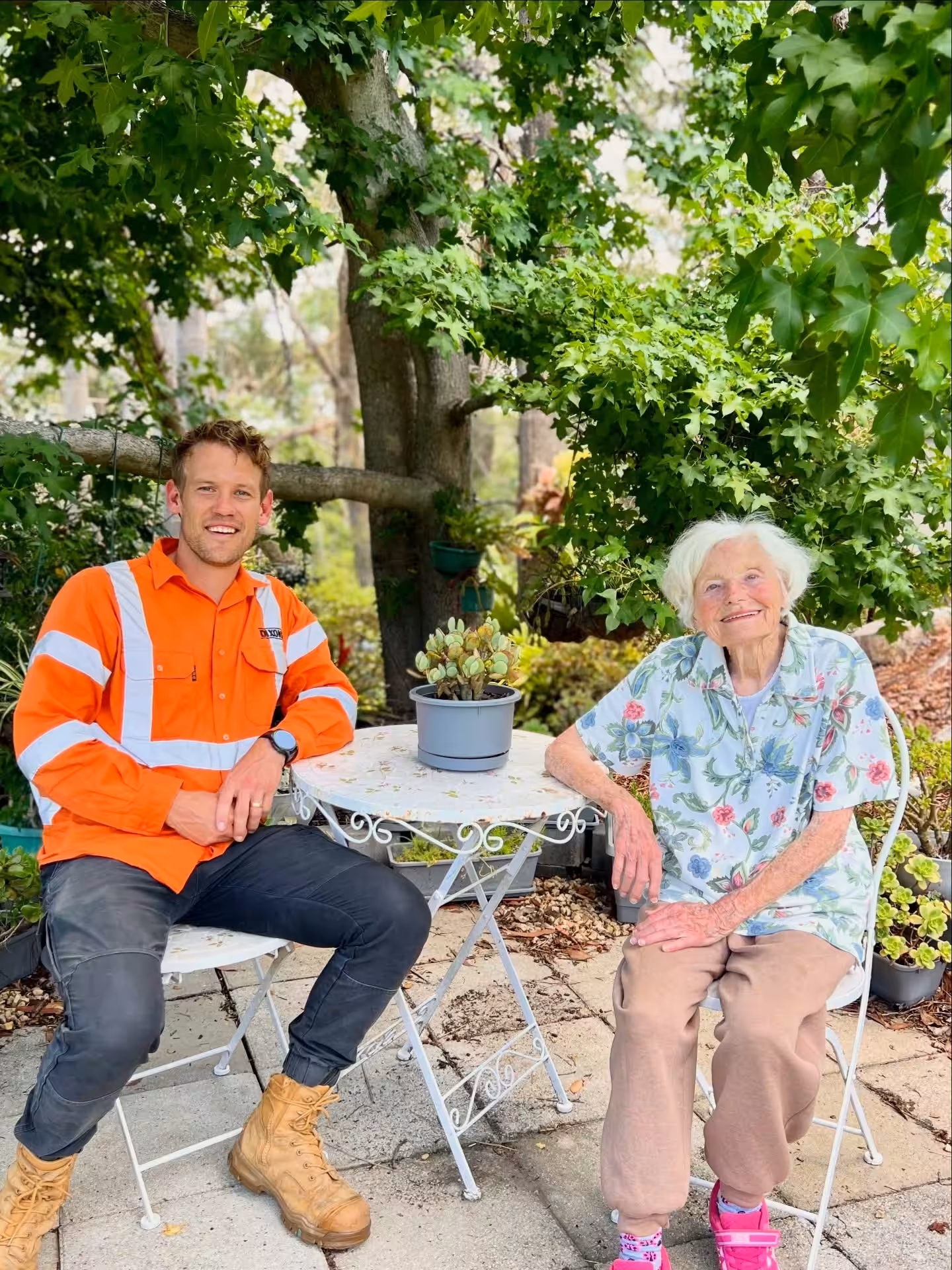 Man and elderly woman sitting at garden table